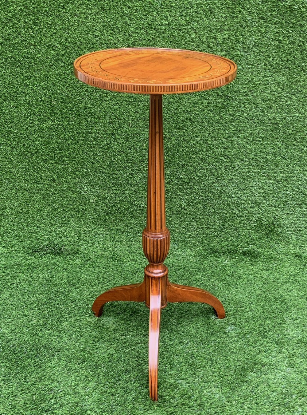 A 19th-century satinwood wine table featuring a circular top with inlaid marquetry detailing, supported by a fluted central pedestal and three downswept tripod legs. View II