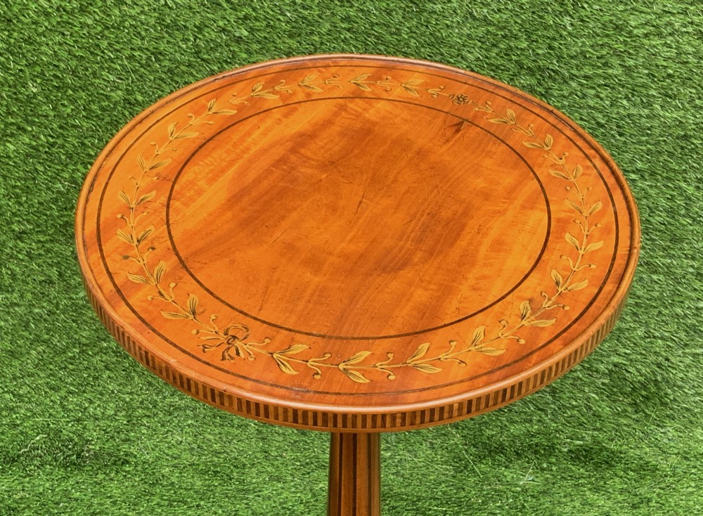 A 19th-century satinwood wine table featuring a circular top with inlaid marquetry detailing, supported by a fluted central pedestal and three downswept tripod legs. View IV