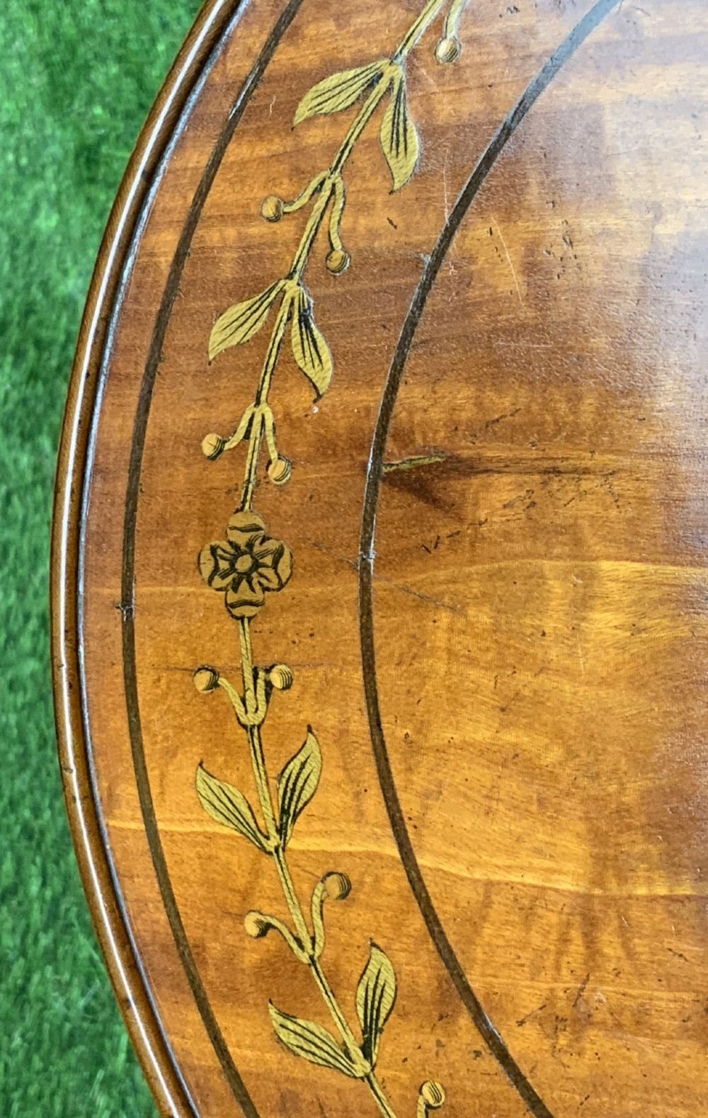 A 19th-century satinwood wine table featuring a circular top with inlaid marquetry detailing, supported by a fluted central pedestal and three downswept tripod legs. View X