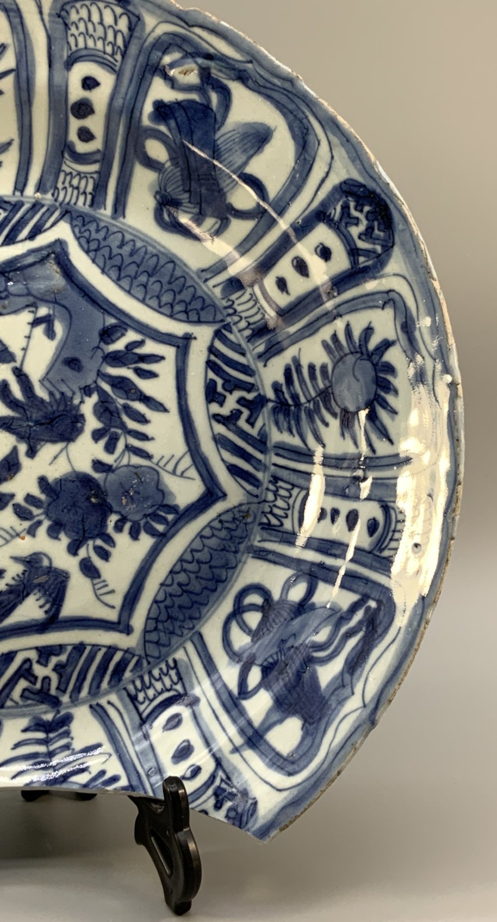 A large 17th-century Japanese Edo period blue and white porcelain charger featuring panelled floral patterns with detached rim fragments in the foreground. View VI