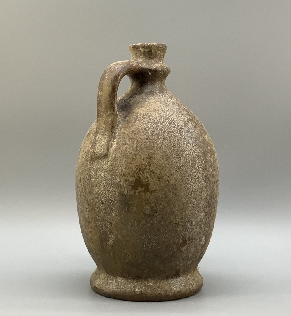 A 19th-century salt-glazed stoneware flagon featuring a mottled brown textured surface, narrow neck, flared rim, and a single loop handle. View IV