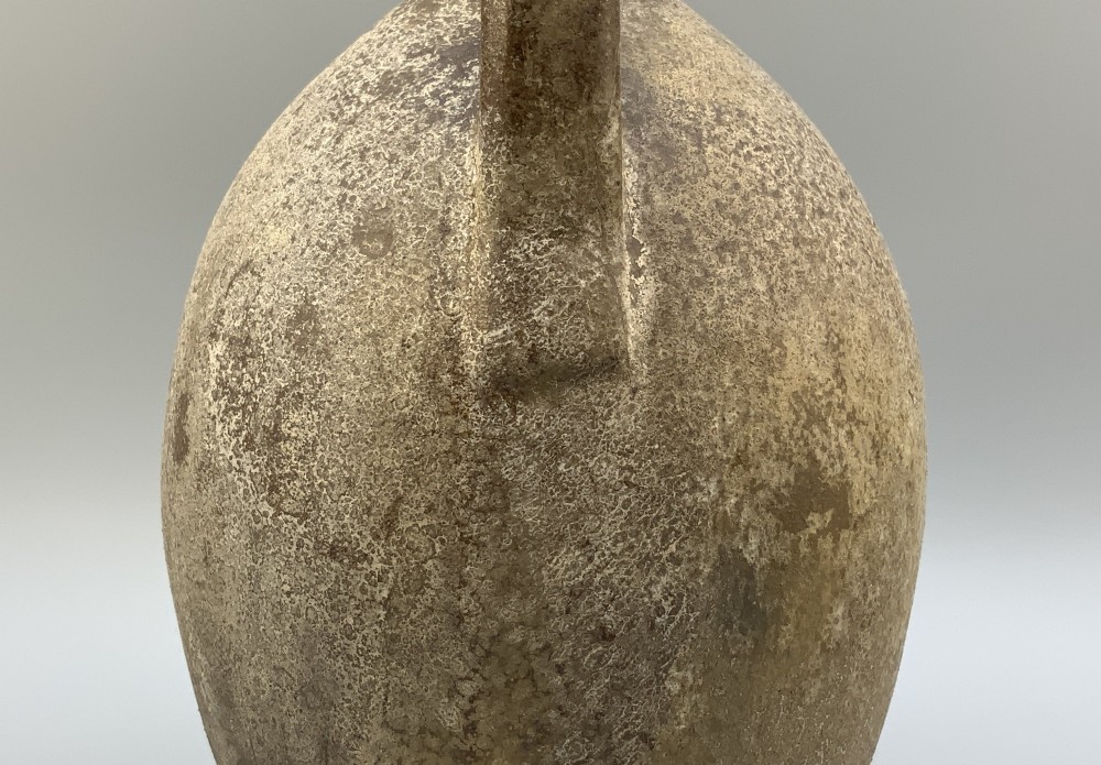 A 19th-century salt-glazed stoneware flagon featuring a mottled brown textured surface, narrow neck, flared rim, and a single loop handle. View VII
