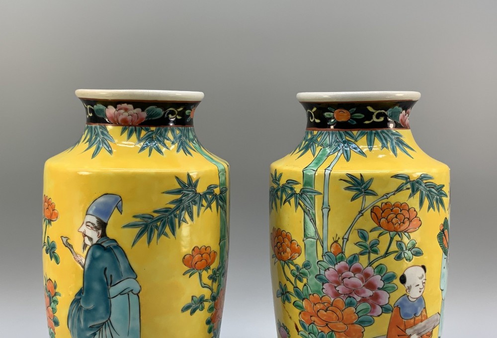 A pair of yellow ground Chinese porcelain vases decorated with painted figures, floral motifs, and green leaf borders around the base. View VI