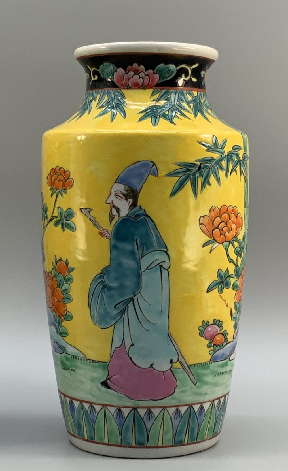 A pair of yellow ground Chinese porcelain vases decorated with painted figures, floral motifs, and green leaf borders around the base. View X