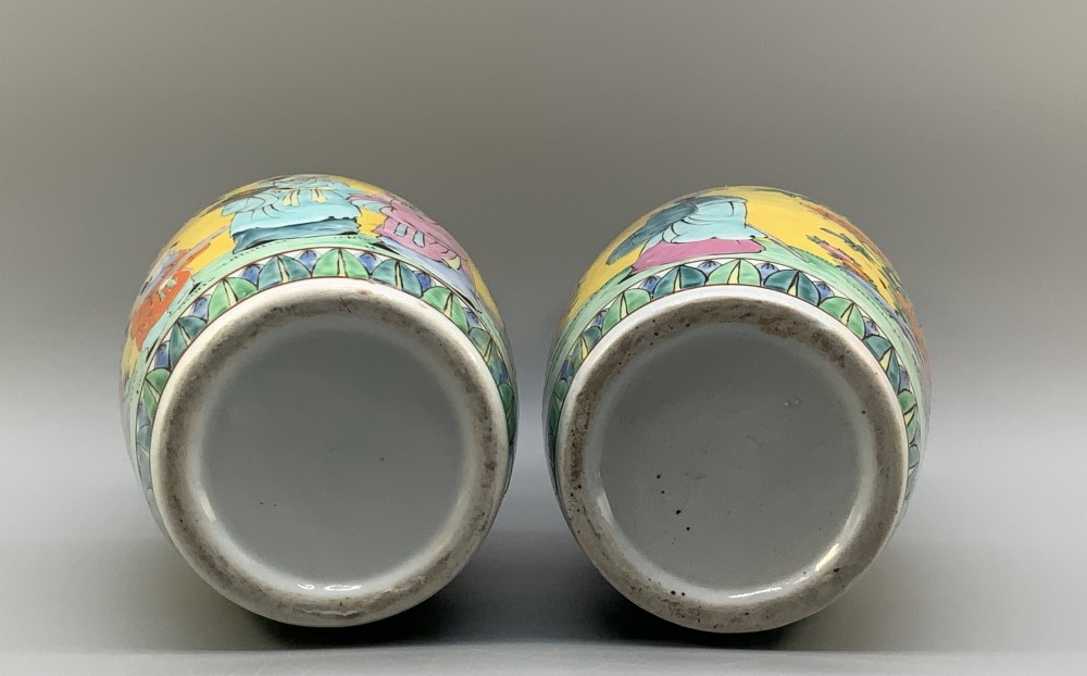 A pair of yellow ground Chinese porcelain vases decorated with painted figures, floral motifs, and green leaf borders around the base. View XI