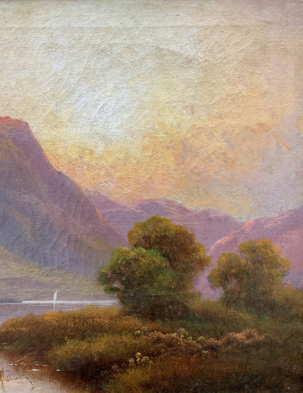 A nineteenth-century oil painting on canvas depicting a Scottish loch and mountains illuminated by a sunset, displayed within a gilt carved frame. View V