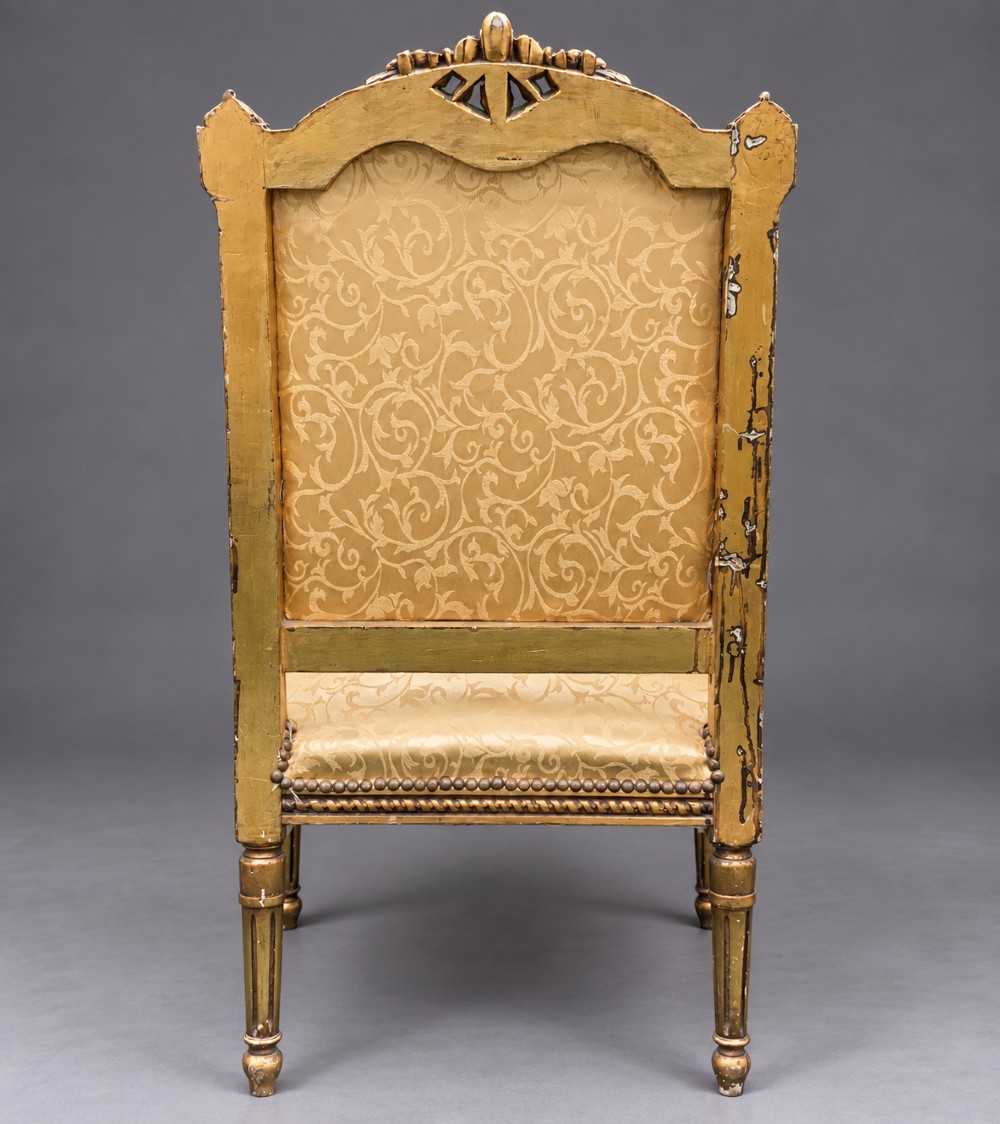 A pair of 19th-century giltwood open armchairs featuring carved leaf detailing, button-tufted gold damask upholstery, and fluted front legs. View VI