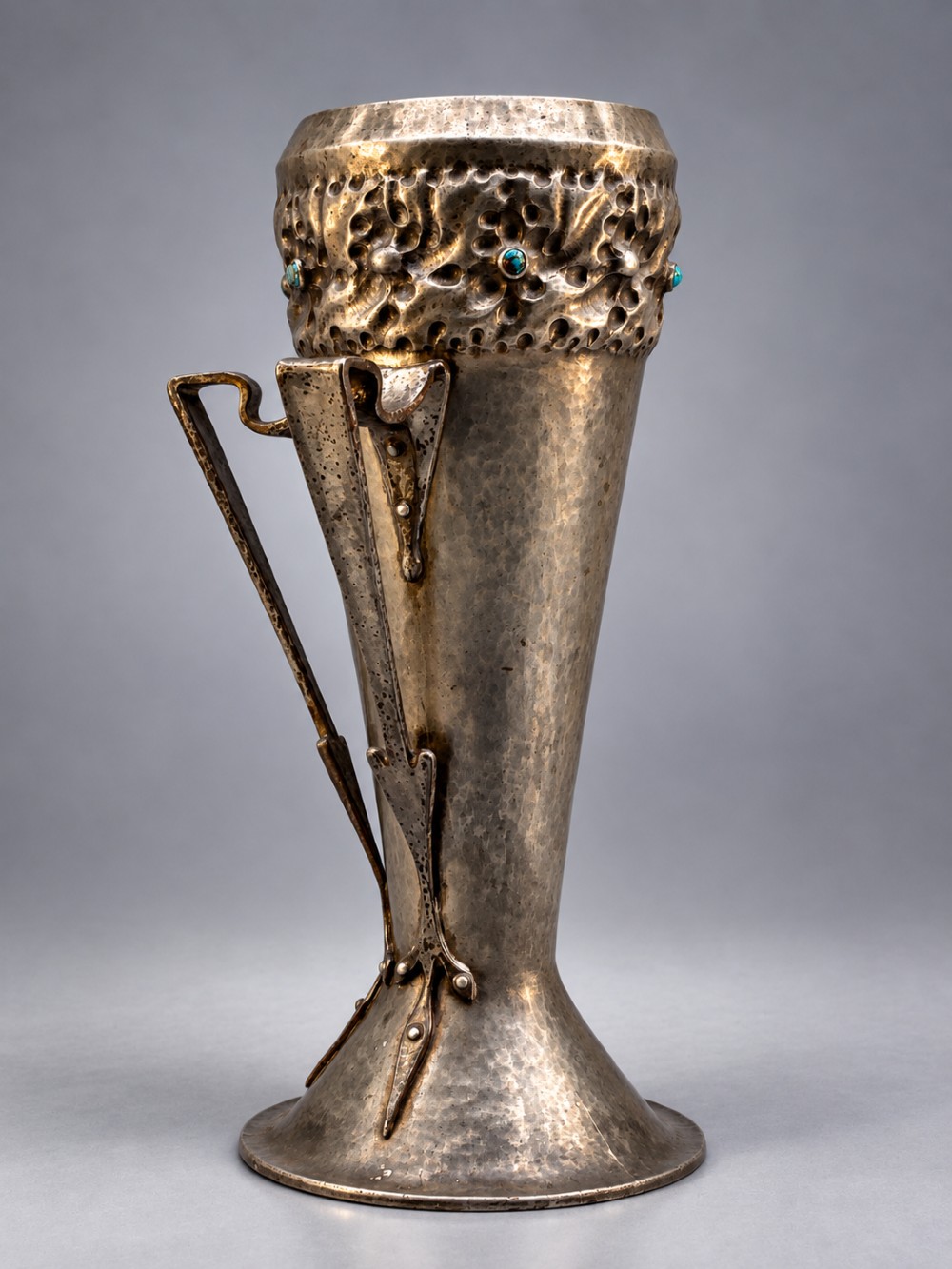 An Arts and Crafts hammered pewter vase featuring raised geometric support fins, a textured upper band, and inlaid turquoise cabochons. View III
