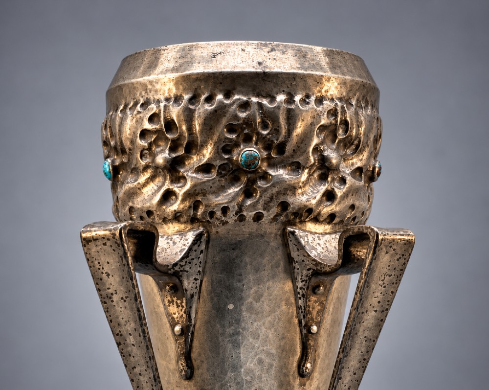 An Arts and Crafts hammered pewter vase featuring raised geometric support fins, a textured upper band, and inlaid turquoise cabochons. View VI