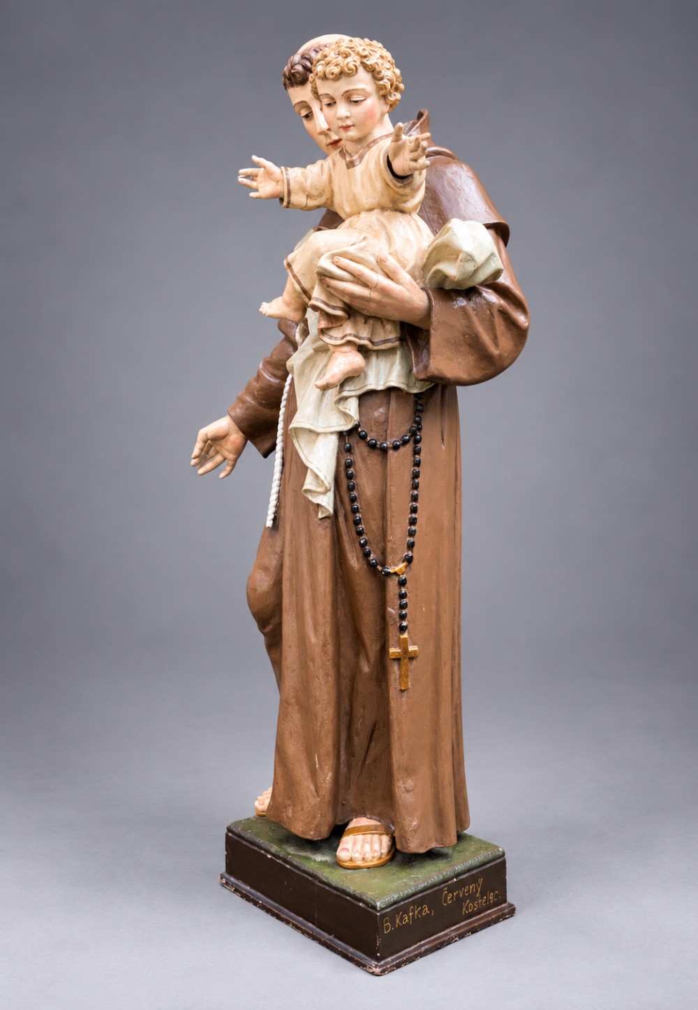 An antique polychrome carved wood sculpture depicting Saint Anthony in a brown Franciscan habit holding the Christ Child. View III