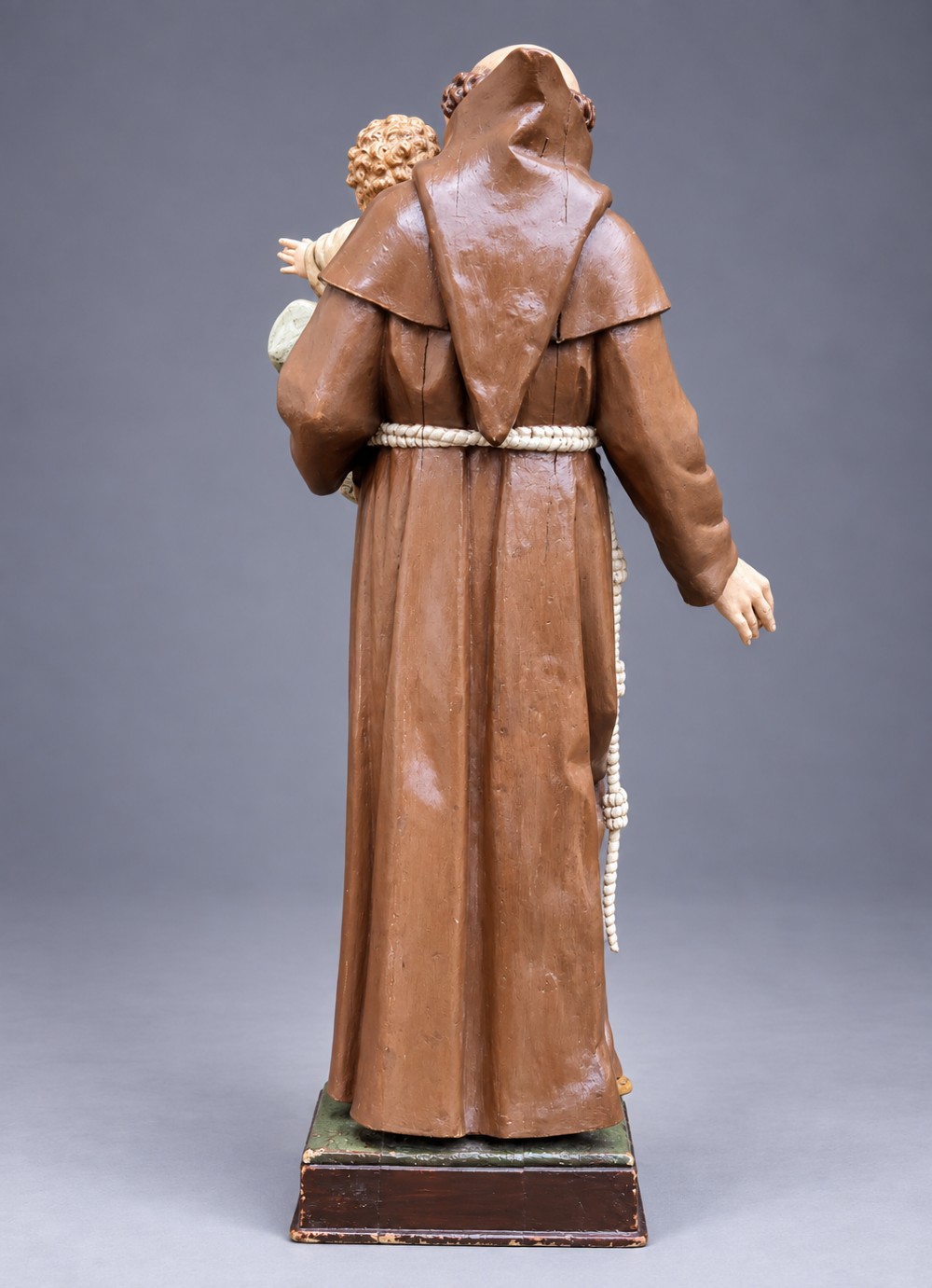 An antique polychrome carved wood sculpture depicting Saint Anthony in a brown Franciscan habit holding the Christ Child. View V