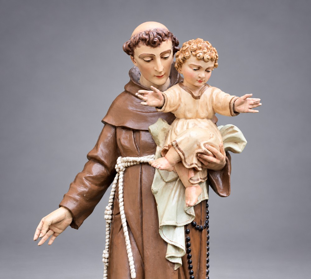 An antique polychrome carved wood sculpture depicting Saint Anthony in a brown Franciscan habit holding the Christ Child. View VI