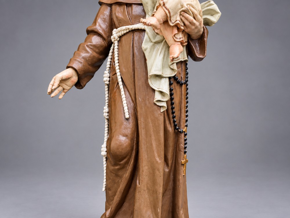An antique polychrome carved wood sculpture depicting Saint Anthony in a brown Franciscan habit holding the Christ Child. View VII
