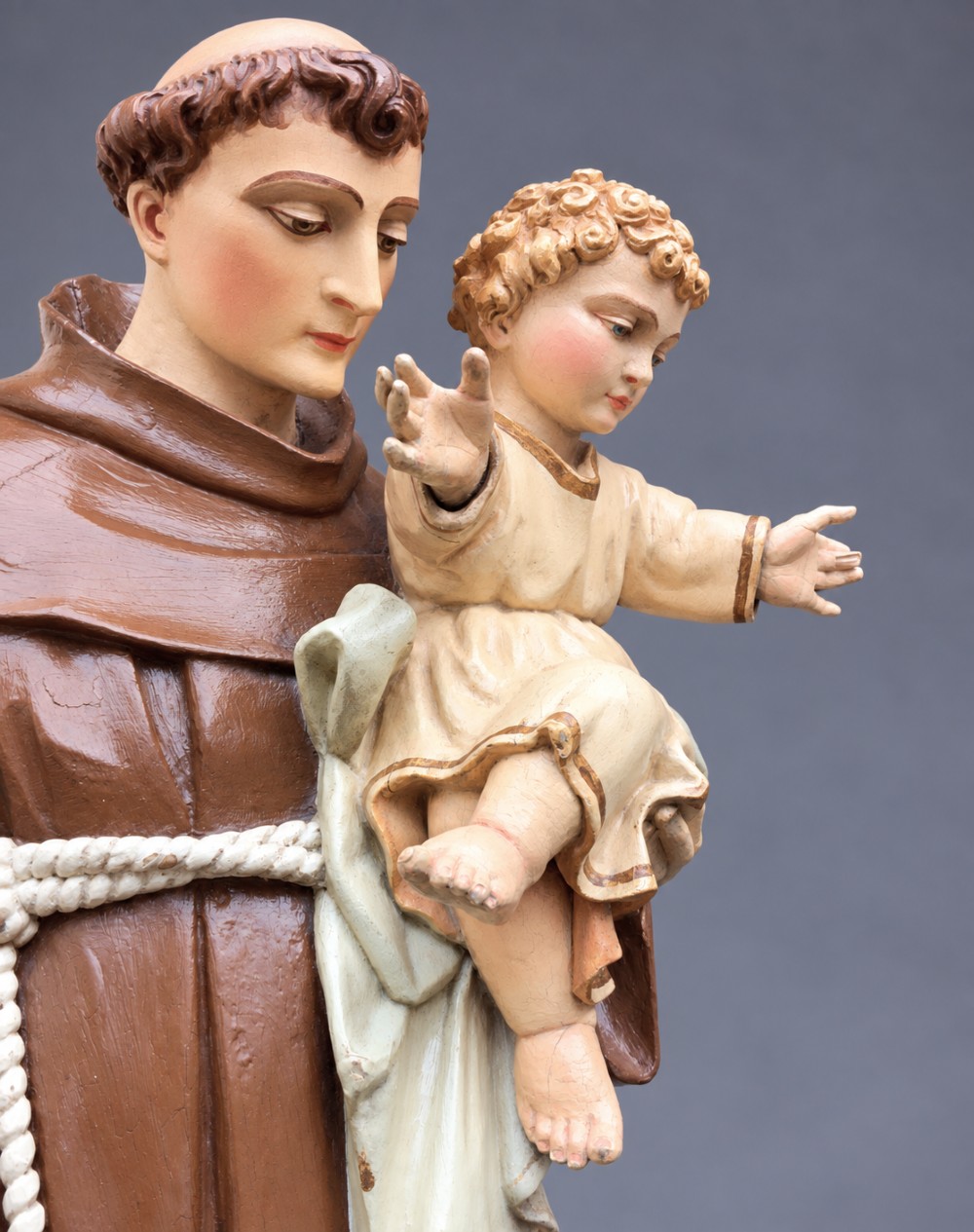 An antique polychrome carved wood sculpture depicting Saint Anthony in a brown Franciscan habit holding the Christ Child. View XI