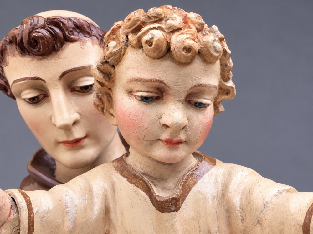 An antique polychrome carved wood sculpture depicting Saint Anthony in a brown Franciscan habit holding the Christ Child. View XII