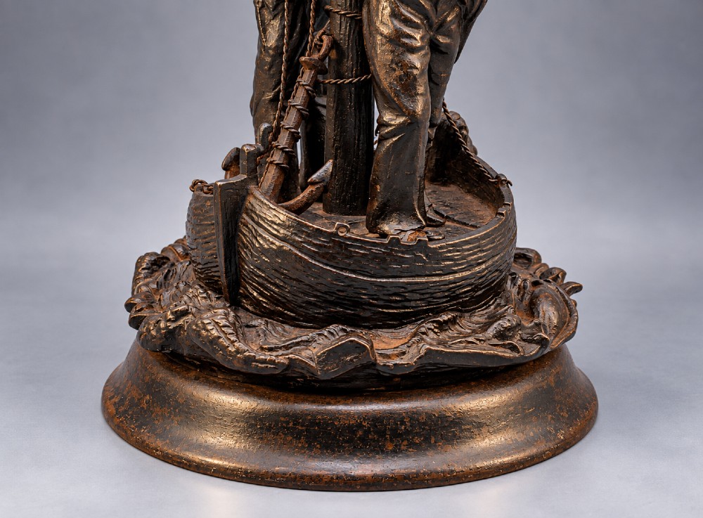 A nineteenth-century dark patinated bronze sculpture depicting two fishermen standing in a small vessel atop sculpted ocean waves, mounted on a rounded base. View VIII