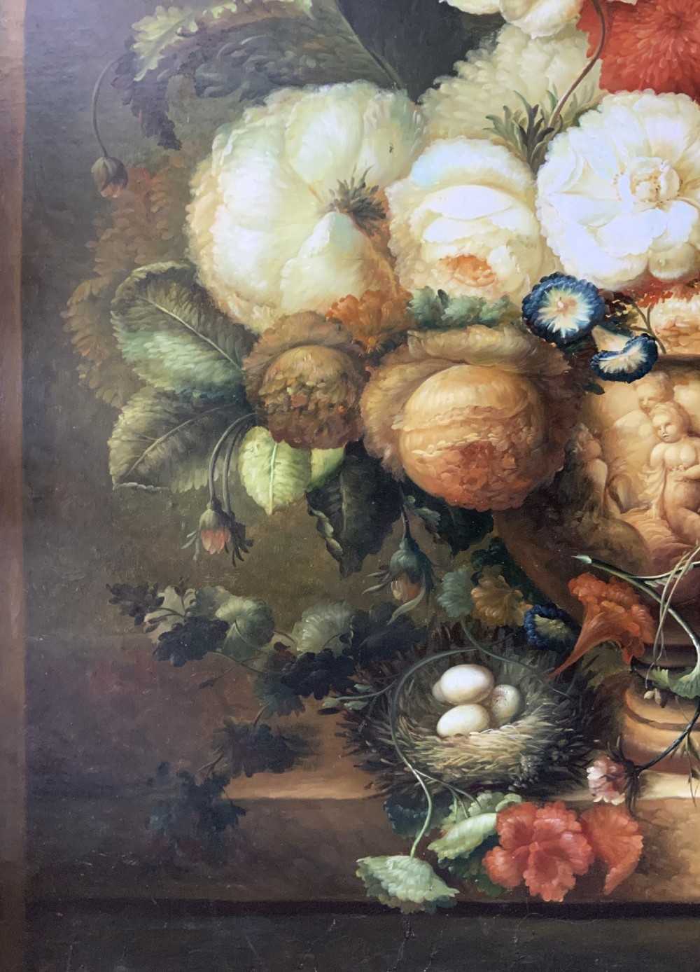 A large scale oil painting featuring a dense arrangement of colourful flowers in a carved classical urn set within a painted stone archway. View XII