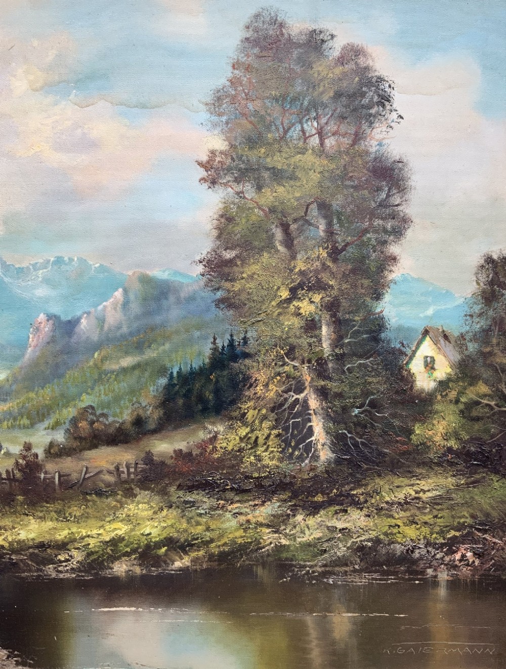 An original alpine landscape oil painting depicting mountains, rural cottages, and a pond reflection, set within an ornate gilded frame. View V