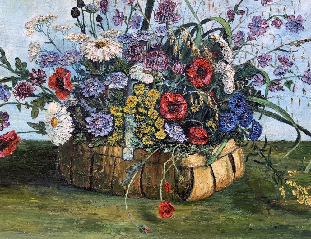 A framed floral still life oil painting depicting a woven basket filled with colourful wildflowers including poppies and daisies against a light blue backdrop. View IV