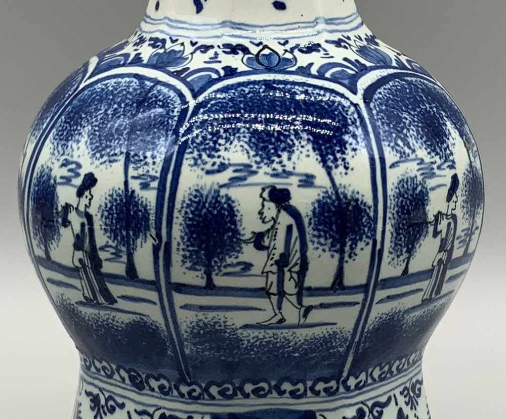 A 17th-century hexagonal Dutch Delft blue and white faience vase decorated with hand-painted chinoiserie figures and floral motifs. View X