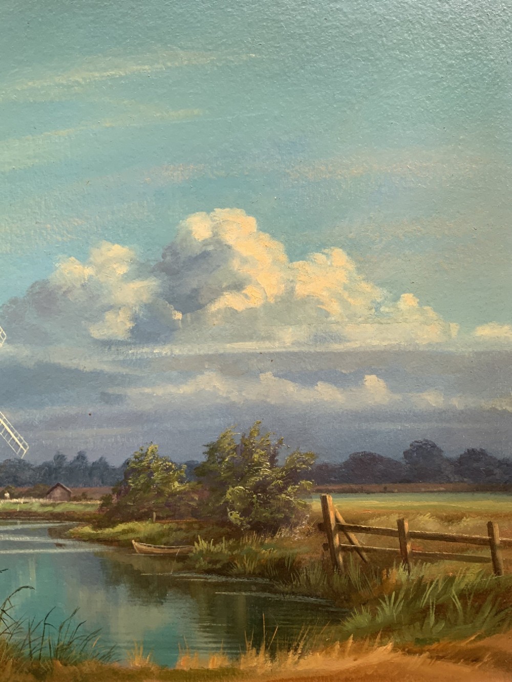 An oil painting depicting Horsey Mill set amidst the Norfolk Broads under a cloud-filled sky, presented in an elaborate gilded swept frame. View V