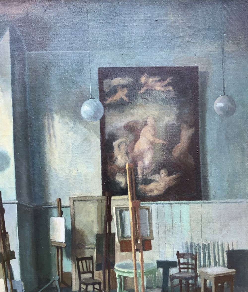 An oil painting on canvas depicting a reclining nude model on a studio floor surrounded by wooden easels, a skylight, and studio furniture, set within a stepped gilt timber frame. View VI