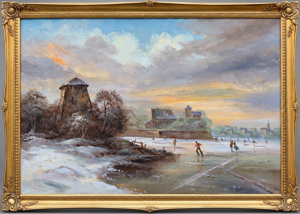 A large framed oil painting depicting figures ice skating on a frozen canal beside historic stone buildings under a winter sky, housed in an ornate gilt frame.