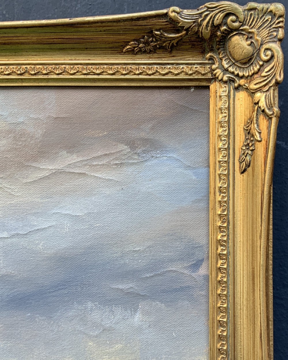 A large framed oil painting depicting figures ice skating on a frozen canal beside historic stone buildings under a winter sky, housed in an ornate gilt frame. View IX