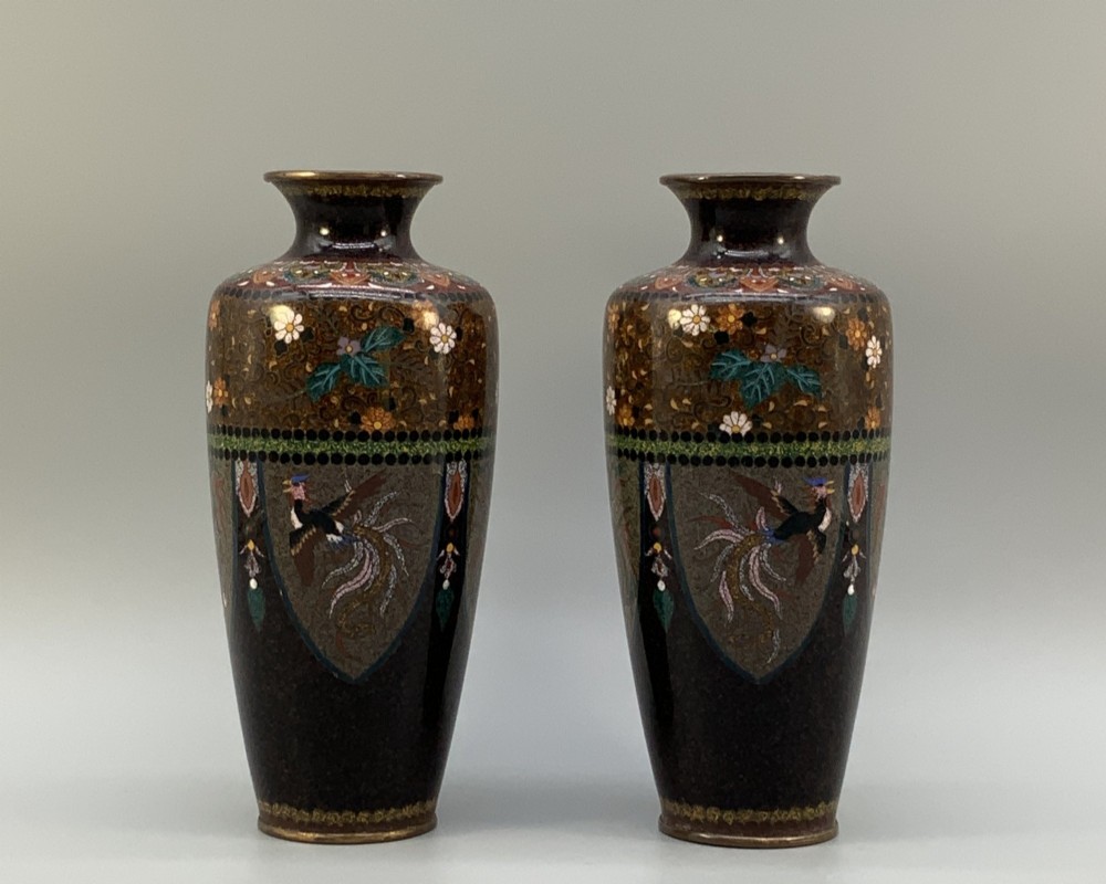A pair of Japanese Meiji period cloisonne enamel vases featuring detailed phoenix birds, floral motifs, and geometric borders on a dark background. View II