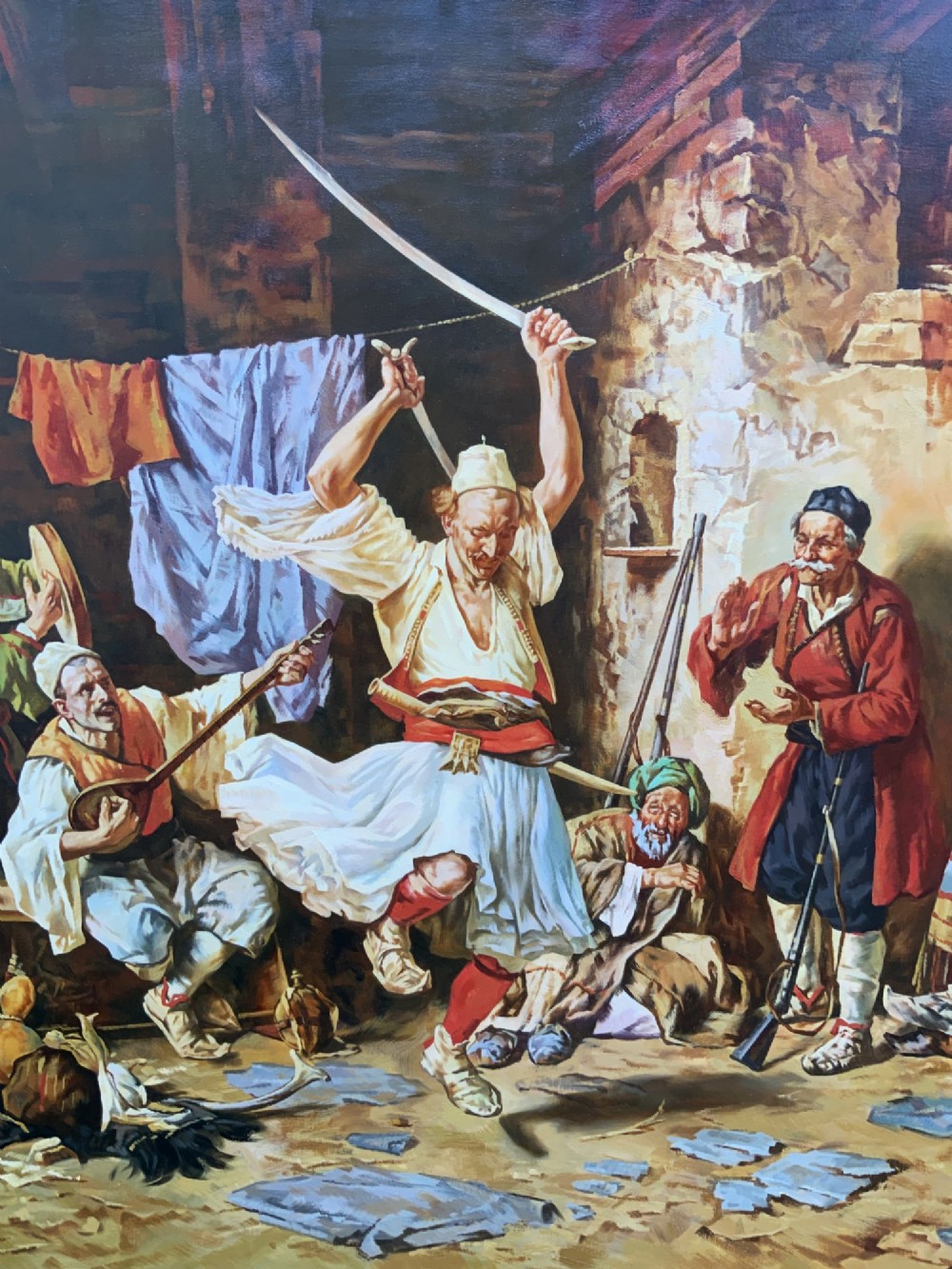 A large mid-century framed oil painting depicting figures in traditional attire watching a man perform a sword dance inside a rustic interior. View VIII