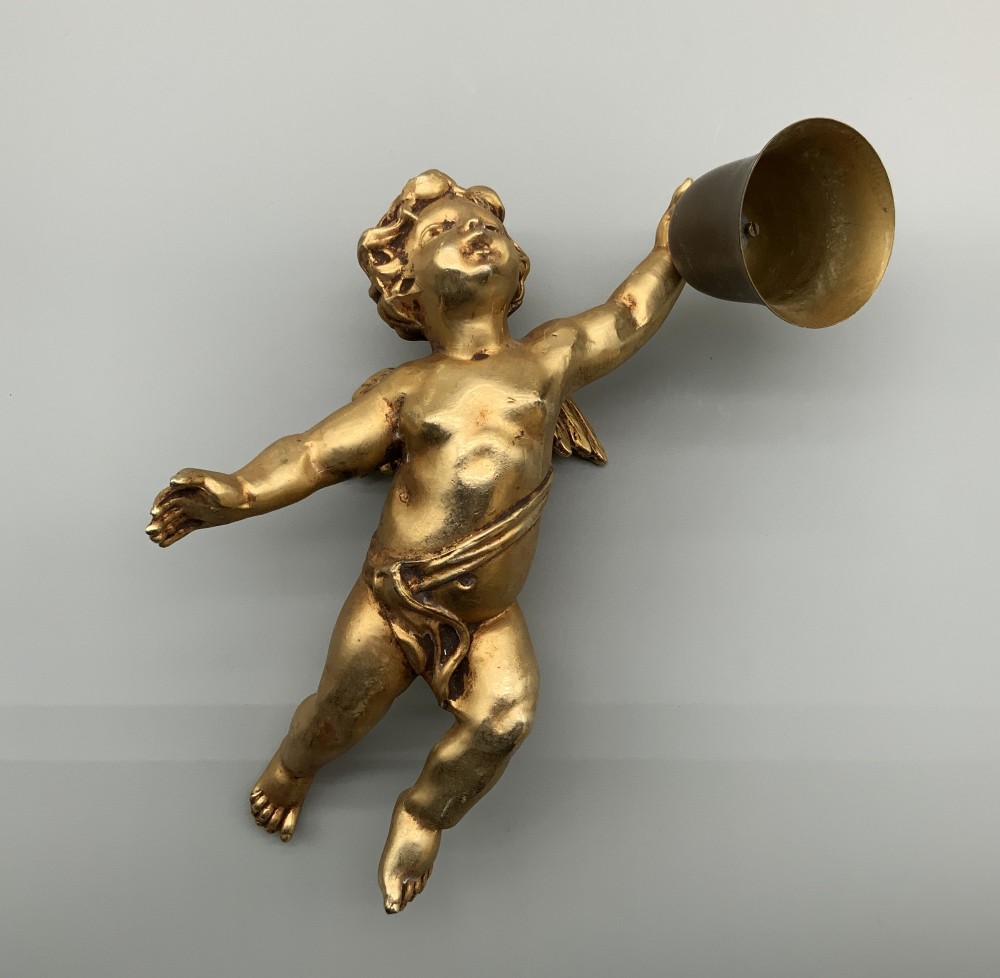 A set of three gilt metal wall sconces crafted in the shape of winged cherubs holding bell-shaped light sockets. View III