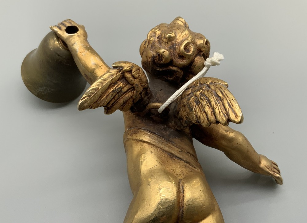 A set of three gilt metal wall sconces crafted in the shape of winged cherubs holding bell-shaped light sockets. View VII