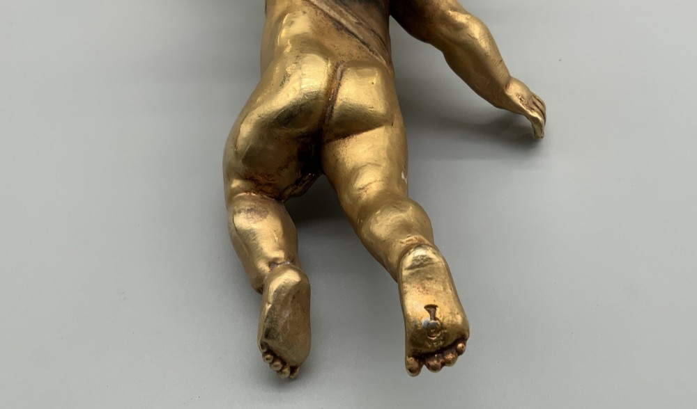 A set of three gilt metal wall sconces crafted in the shape of winged cherubs holding bell-shaped light sockets. View VIII