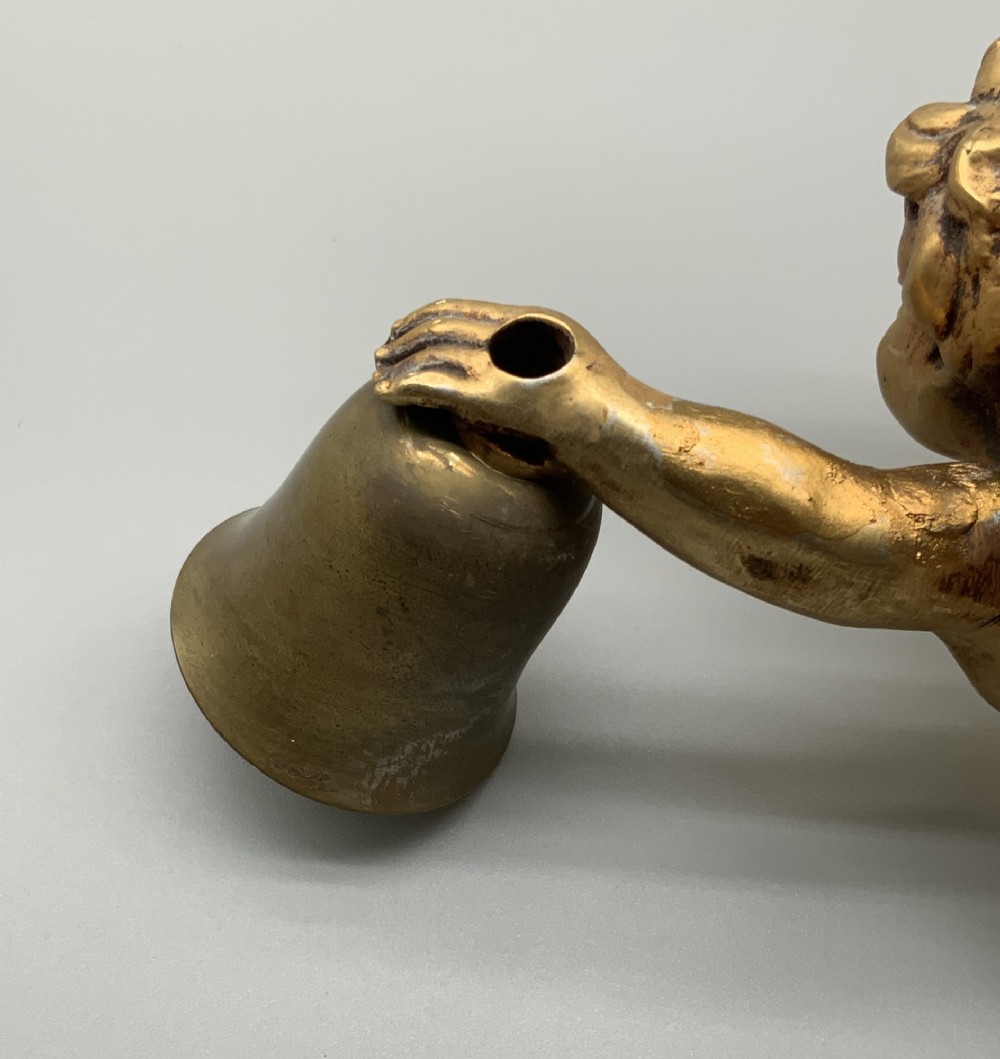 A set of three gilt metal wall sconces crafted in the shape of winged cherubs holding bell-shaped light sockets. View IX