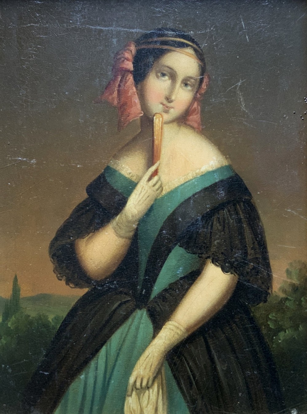 A framed 19th-century miniature oil painting depicting a seated woman in a teal dress and dark shawl holding a fan. View II