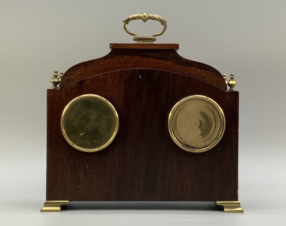 An Edwardian mahogany desk compendium featuring an inlaid floral swag motif, central thermometer, clock dial, barometer dial, and top brass handle. View X