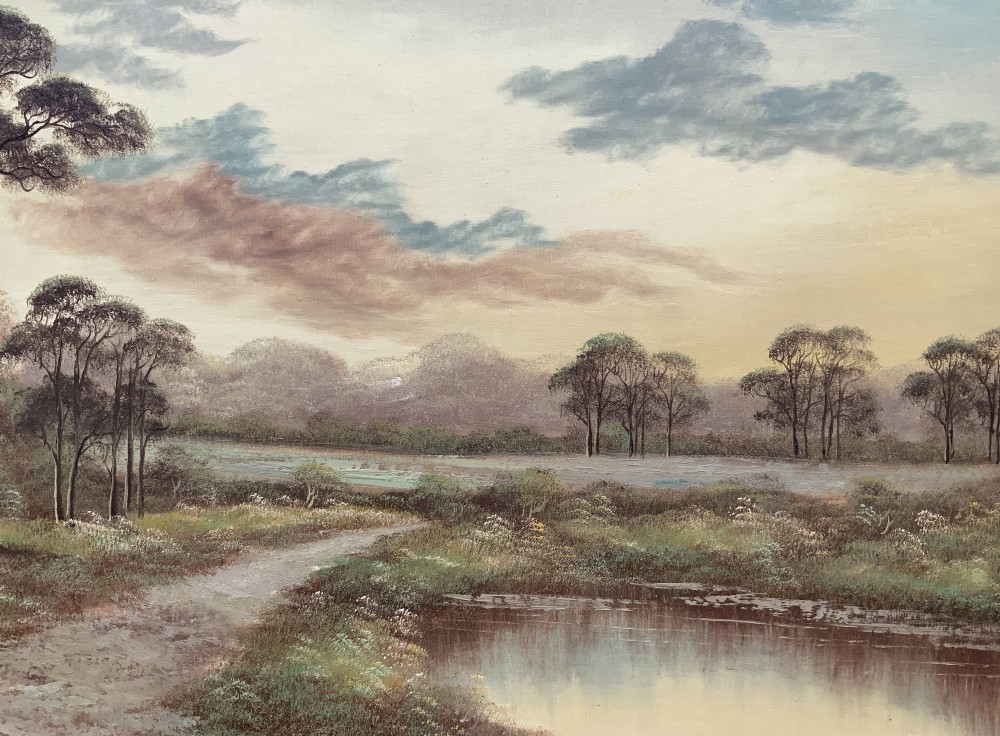A twentieth-century framed oil painting depicting a countryside path alongside a reflective pond, surrounded by tall trees and distant hills under a clouded sky. View III