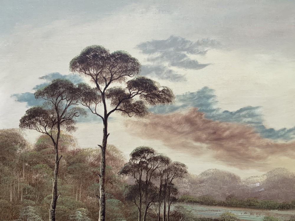 A twentieth-century framed oil painting depicting a countryside path alongside a reflective pond, surrounded by tall trees and distant hills under a clouded sky. View VII
