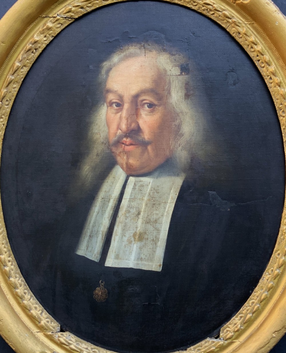An oval 17th-century oil painting depicting a gentleman with grey hair, a moustache, and white falling bands collar in a carved gold frame. View II
