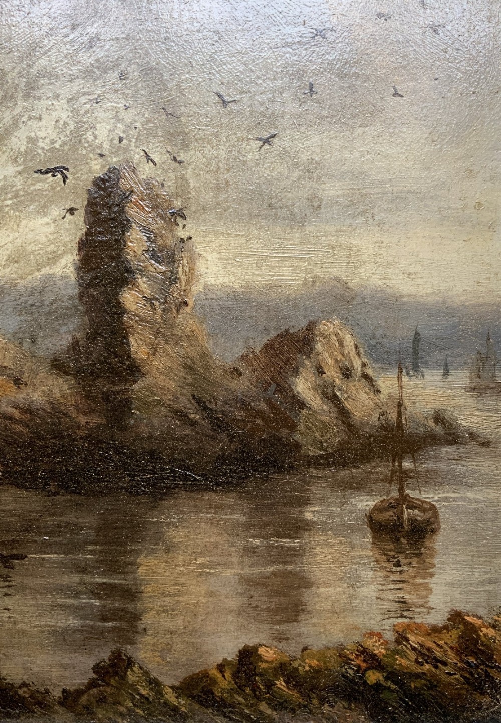 A 19th-century miniature oil painting depicting a coastal cliff scene with a prominent rock stack, small boats, and birds in flight, set within a dark wooden frame. View VI
