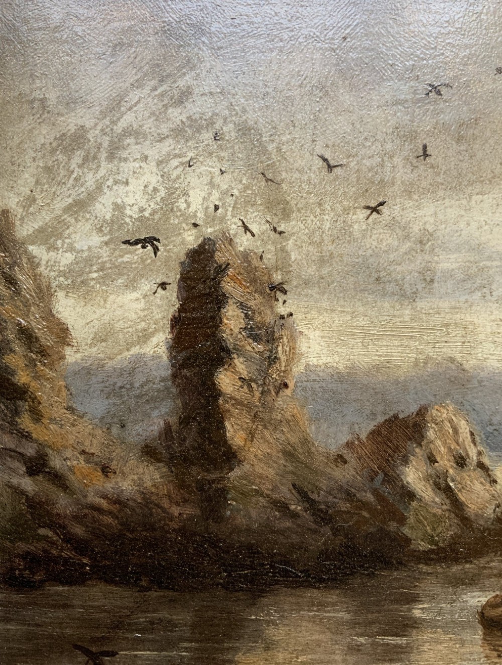 A 19th-century miniature oil painting depicting a coastal cliff scene with a prominent rock stack, small boats, and birds in flight, set within a dark wooden frame. View VII