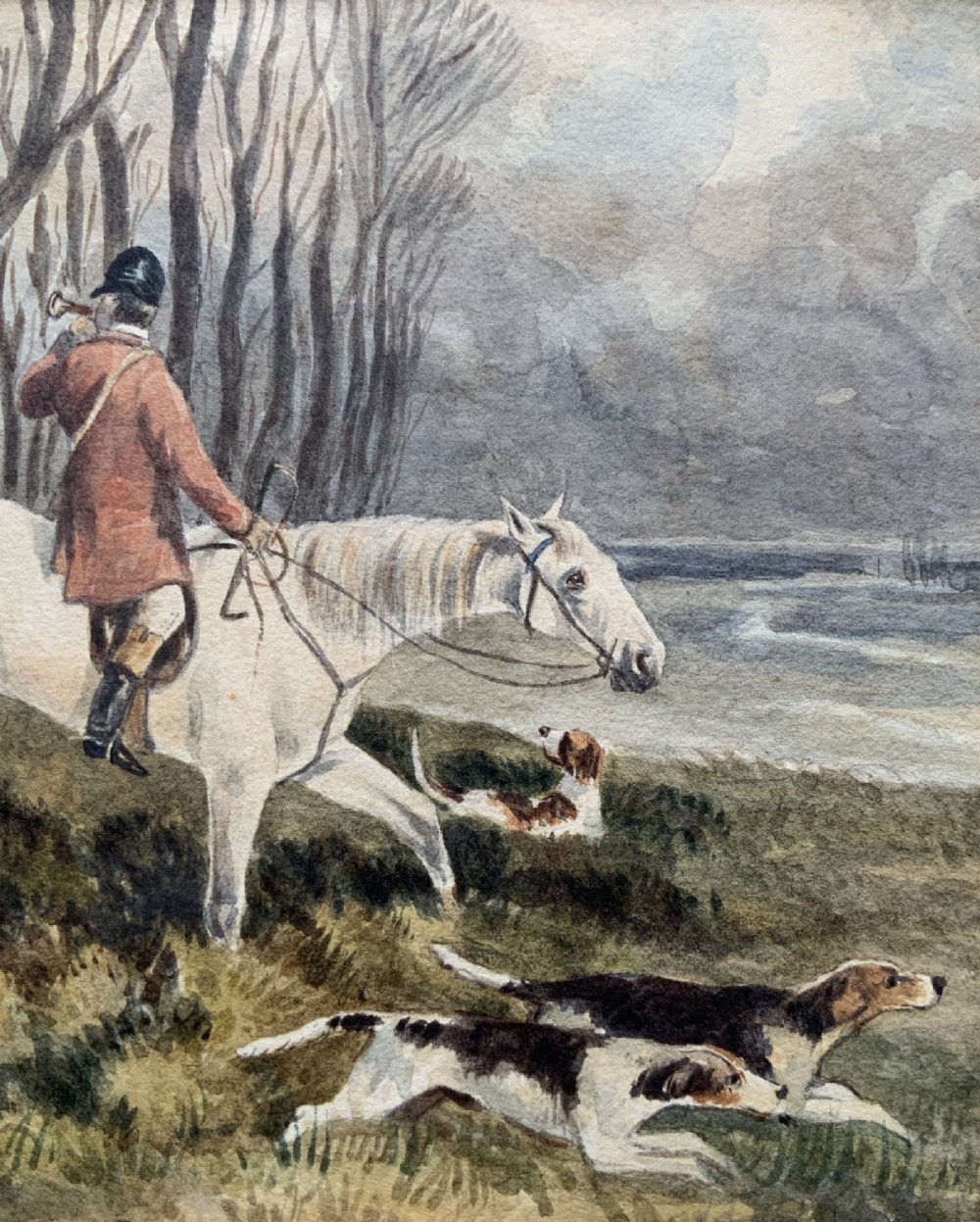 A framed 19th-century watercolour painting depicting a huntsman in a red coat riding a white horse alongside hunting hounds through a woodland landscape. View VII