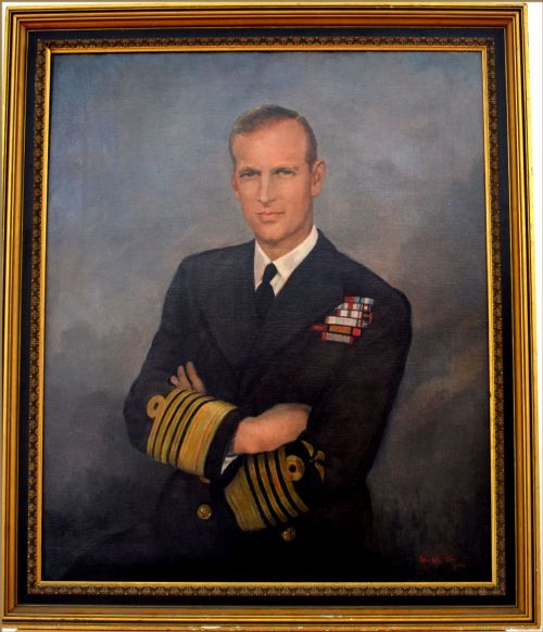 fig 1. A mid-20th-century oil portrait of Prince Philip in a dark navy blue Admiral of the Fleet naval uniform with gold lace cuffs against a muted blue background.