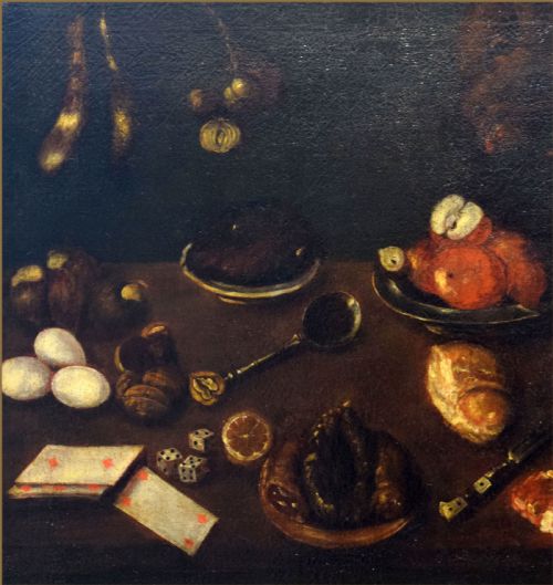 fig 3. A 17th-century Spanish Baroque oil painting depicting a tabletop larder scene with meat, eggs, walnuts, bread, dice, playing cards, and utensils against a dark background.