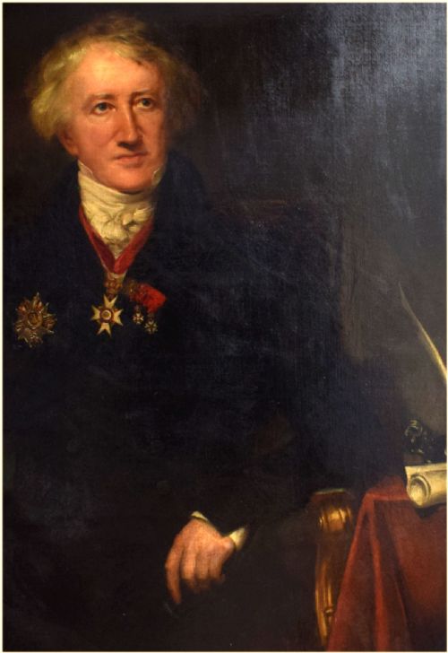 fig 1. An antique oil painting on canvas depicting a seated gentleman with white hair wearing a dark coat decorated with medals, holding a green book beside a red-draped table.