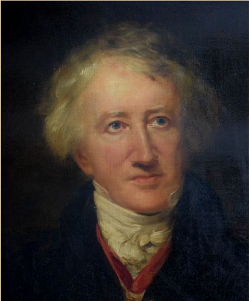 fig 3. An antique oil painting on canvas depicting a seated gentleman with white hair wearing a dark coat decorated with medals, holding a green book beside a red-draped table.