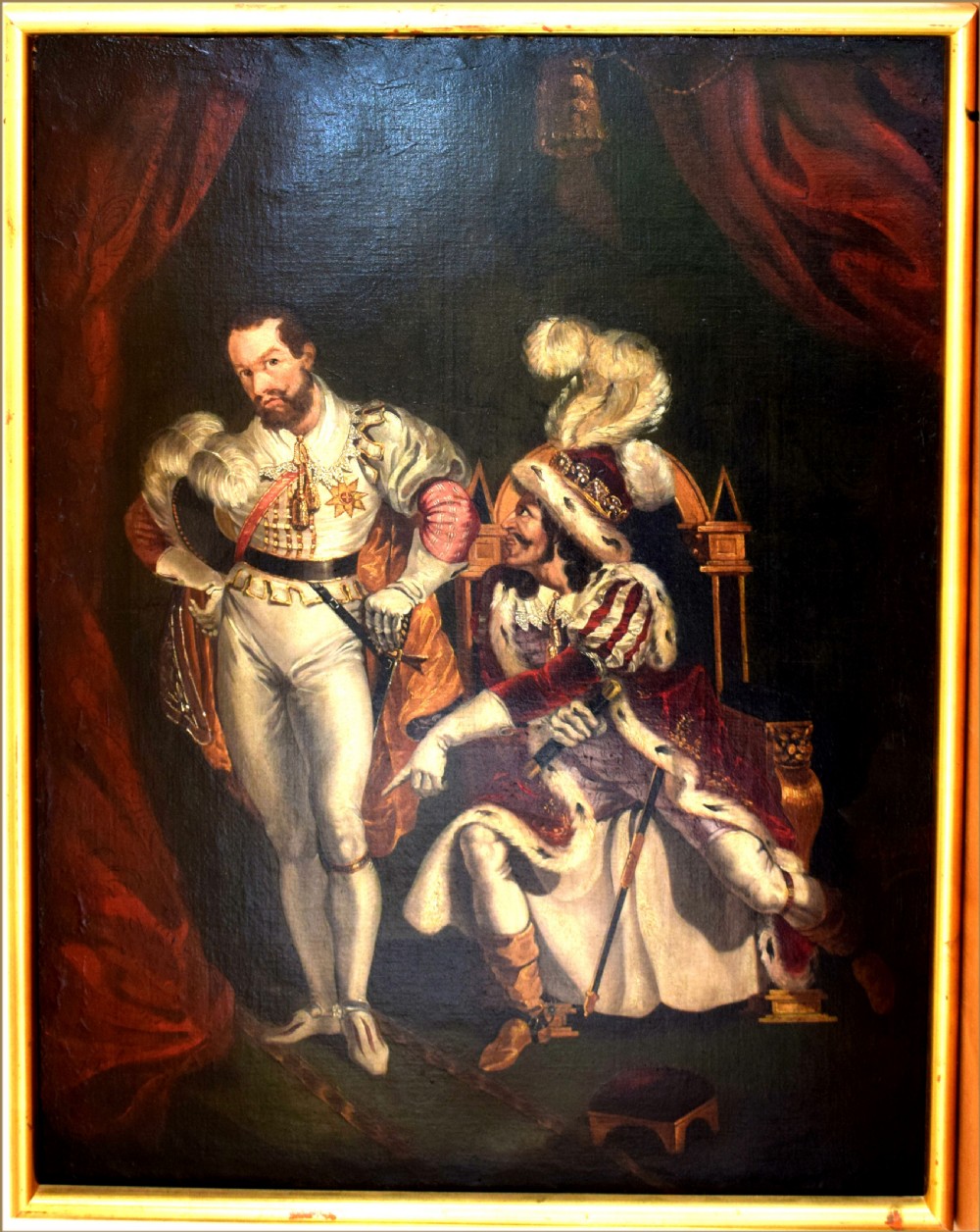 An oil painting depicting two men in elaborate 19th-century theatrical costumes, with one seated wearing a feathered cap and the other standing in a white doublet against red drapery. View IV