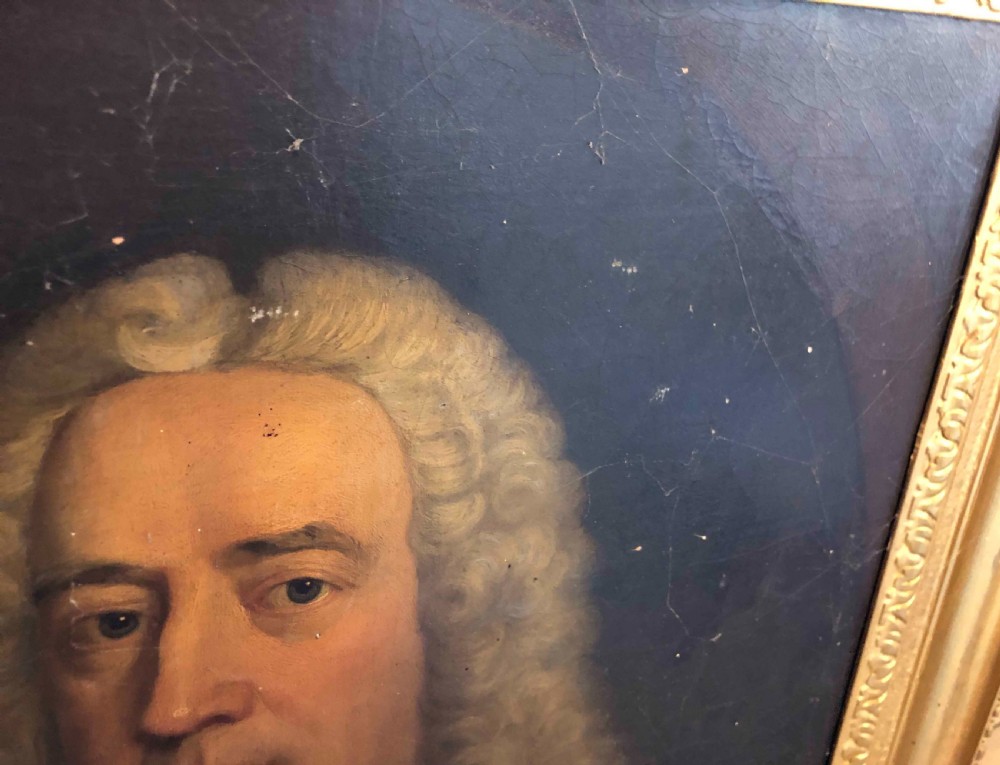 A mid-eighteenth-century oil painting depicting a gentleman with a powdered wig, white cravat, and brown coat set within a painted feigned oval frame. View II