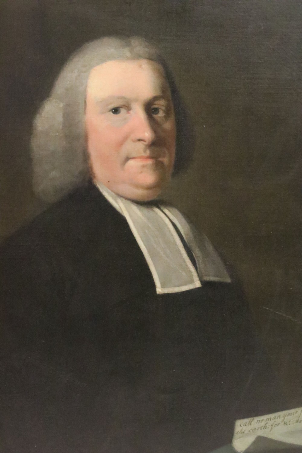 An eighteenth-century oil painting depicting Reverend Patrick Bennet in a black coat, powdered wig, and white clerical bands, holding a inscribed scroll. View IV