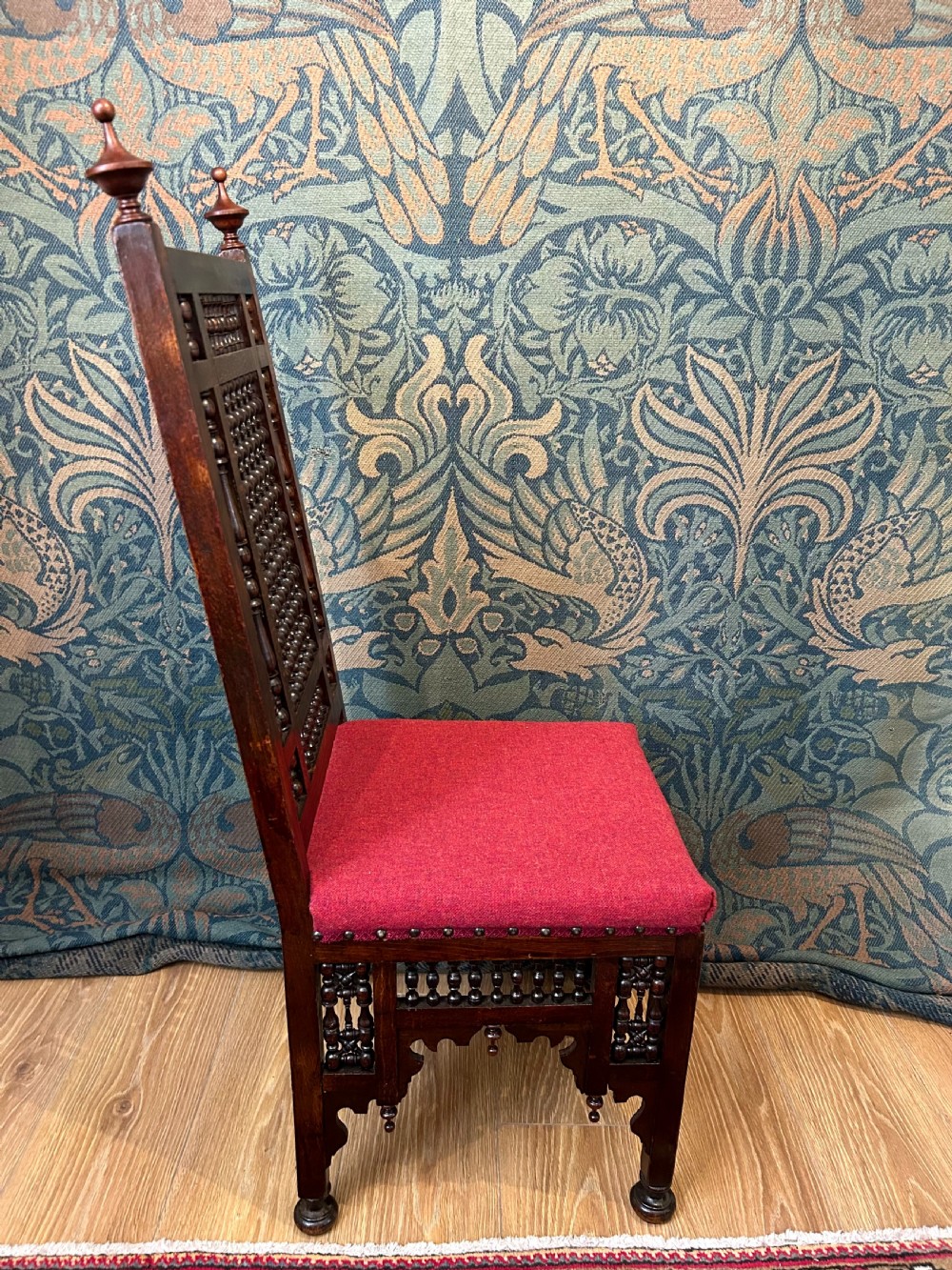 A pair of dark wood Cairene side chairs featuring turned bobbin mashrabiya latticework on the backrests and lower aprons, topped with corner finials and fitted with red wool upholstered seats. View II